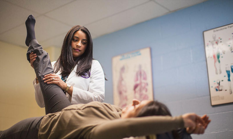 A chiropractic student working on a patient